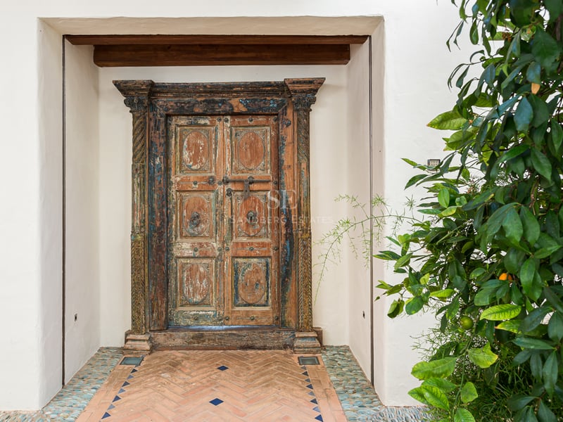 Vue panoramique d'une villa moderne avec piscine à débordement, jardin luxuriant et terrasse couverte. Design élégant et contemporain.