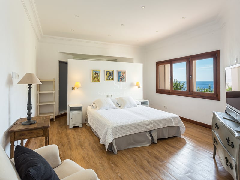 Vue extérieure d'une villa moderne avec piscine à débordement, grandes baies vitrées, jardin luxuriant et architecture contemporaine. Design élégant.