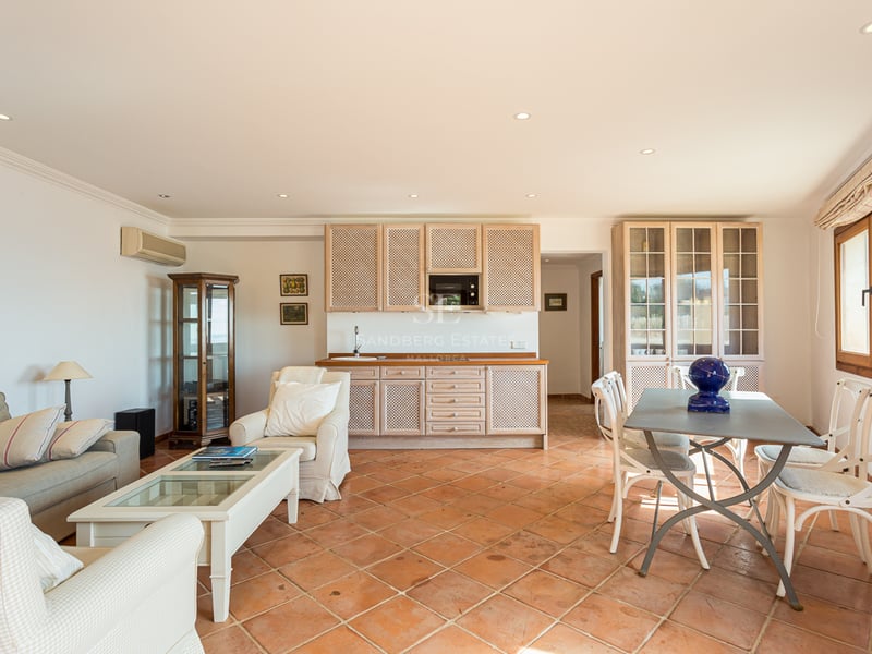 Extérieur d'une villa moderne avec piscine, jardin luxuriant et architecture élégante. Éclairage ambiant chaleureux.