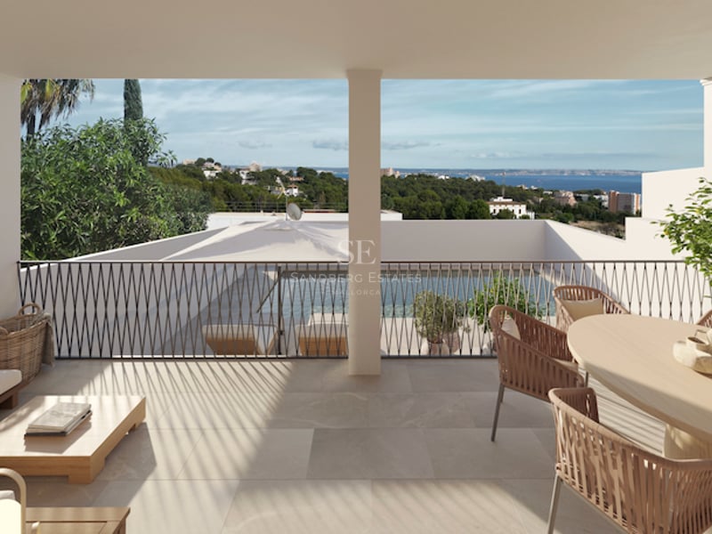 Überdachte Terrasse mit Korbmöbeln und Blick auf einen Pool und das Mittelmeer.