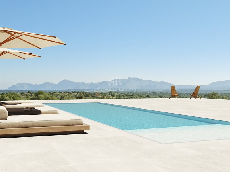 Piscine rectangulaire entourée de dalles en pierre, lits de jour de luxe et parasols avec vue lointaine sur les montagnes.