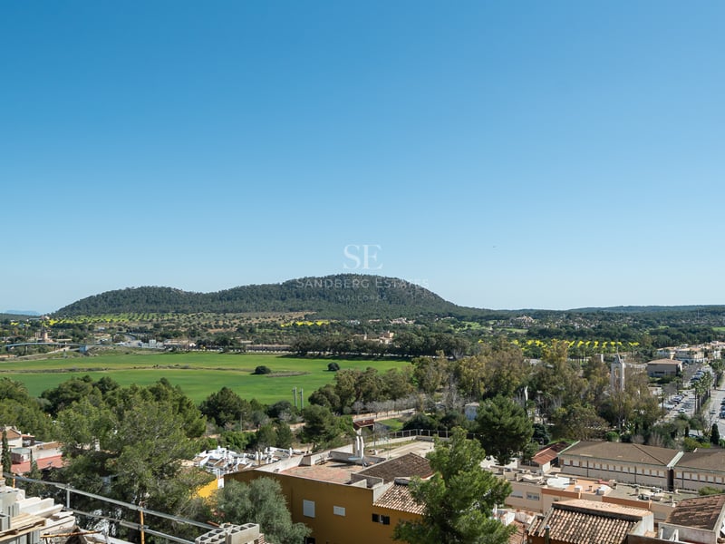 Vue surélevée d'un village méditerranéen, de vallées et de collines sous un ciel bleu clair depuis un chantier.