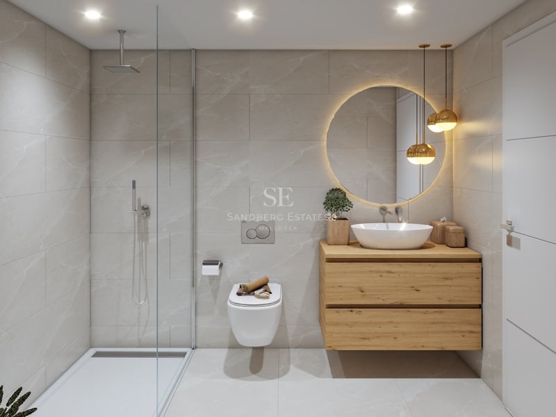 Contemporary bathroom featuring a glass walk-in shower, wooden vanity, round backlit mirror, and beige stone tiles.