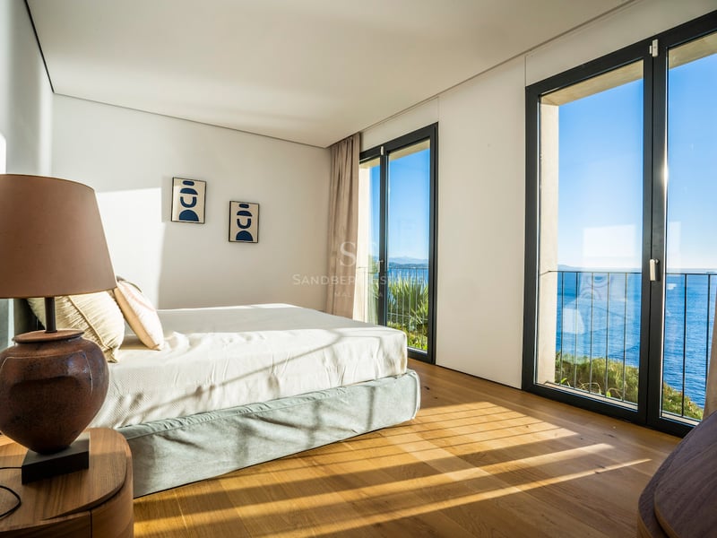 Modernes Schlafzimmer mit Eichenparkett, bodentiefen Fenstern und Blick auf das azurblaue Mittelmeer.