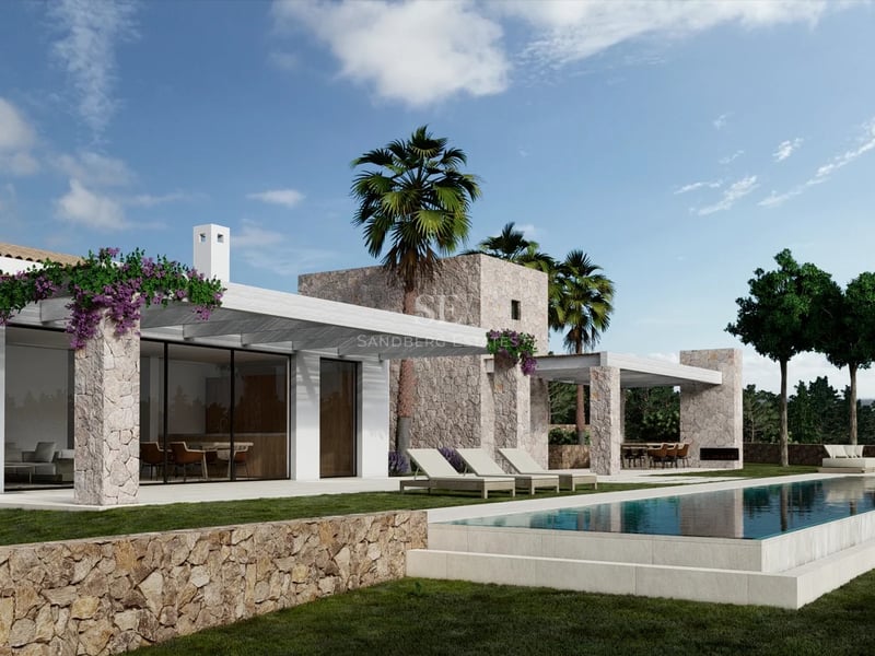 Villa moderne en pierre et blanc avec piscine, transats et palmiers sous un ciel bleu.