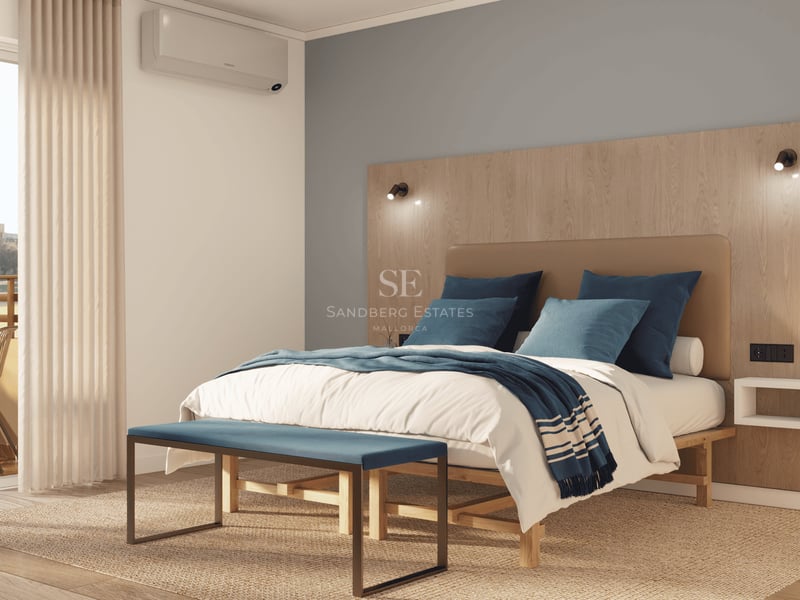 Chambre lumineuse avec grand lit, tête de lit en bois, banc bleu et accès à une terrasse ensoleillée.