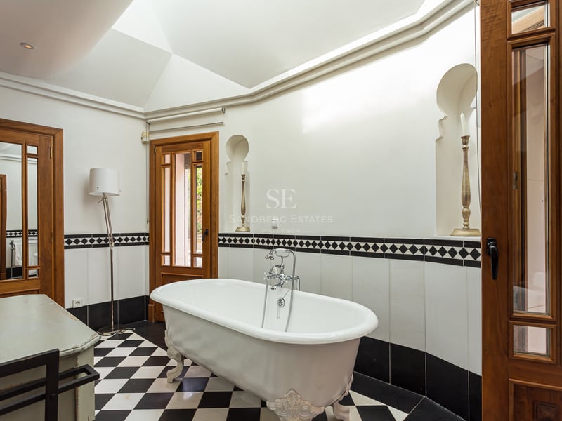 Extérieur de villa moderne avec piscine à débordement, grandes terrasses, et design architectural minimaliste. Végétation luxuriante et vues panoramiques.