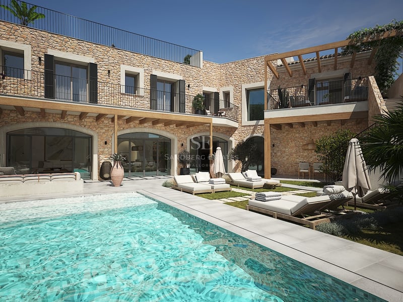 Extérieur de villa de luxe avec piscine turquoise, murs en pierre naturelle et chaises longues élégantes sous pergolas.