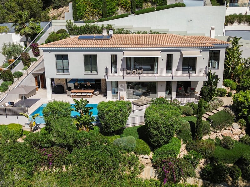 Vue extérieure d'une villa moderne avec piscine à débordement. Design minimaliste, grandes baies vitrées et environnement naturel luxuriant.