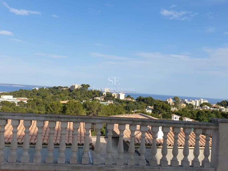 Spacious balcony with sea view and pool. Modern architecture featuring glass railings and stylish outdoor furniture.