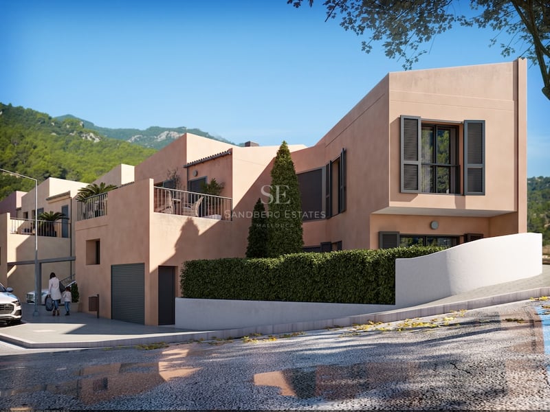 Modern persikofärgad villa med mörka fönsterluckor och terrass mot en bergig bakgrund.