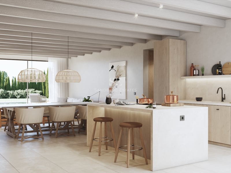 Cuisine moderne avec îlot central, poutres en bois et salle à manger donnant sur le jardin par de grandes baies vitrées.