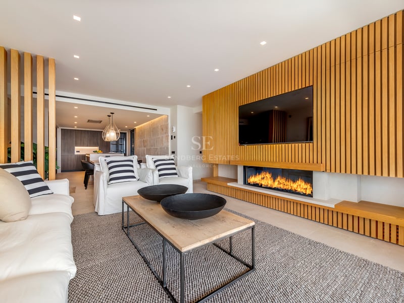 Salon moderne avec mur en tasseaux de chêne, cheminée linéaire intégrée et canapés blancs confortables.