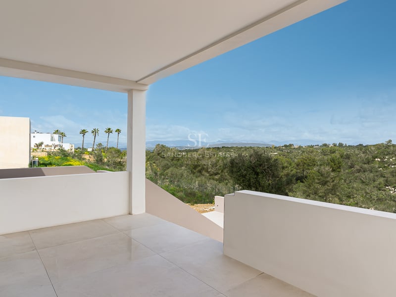 Minimalistische weiße überdachte Terrasse mit polierten Fliesen und Blick auf ein grünes Tal und Berge.