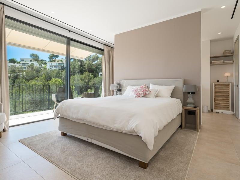 Vaste salon avec baies vitrées, cheminée moderne, canapés design, éclairage chaleureux et accès terrasse avec vue.