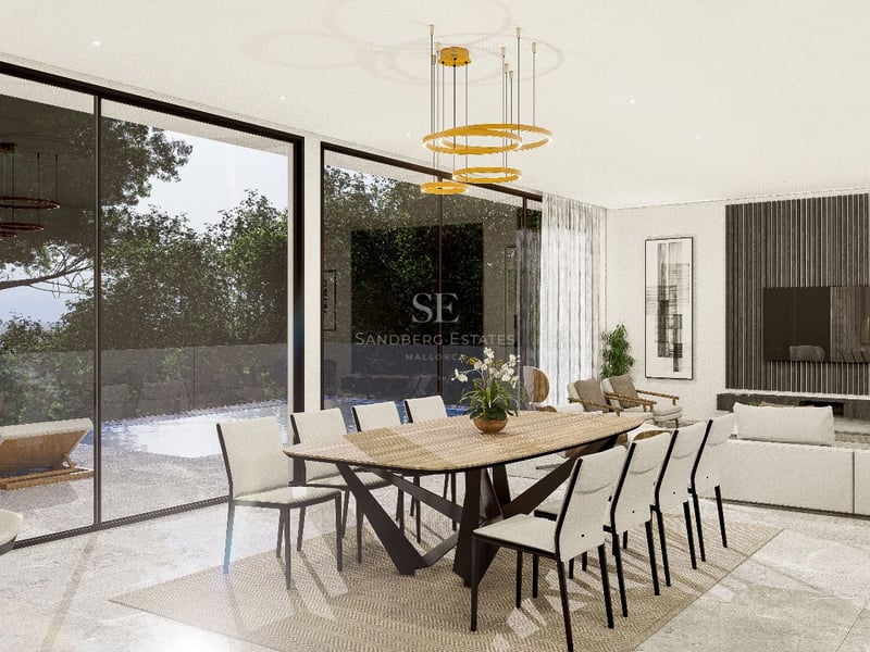 Salle à manger moderne avec table en bois, luminaire doré et baies vitrées donnant sur la piscine et le jardin.