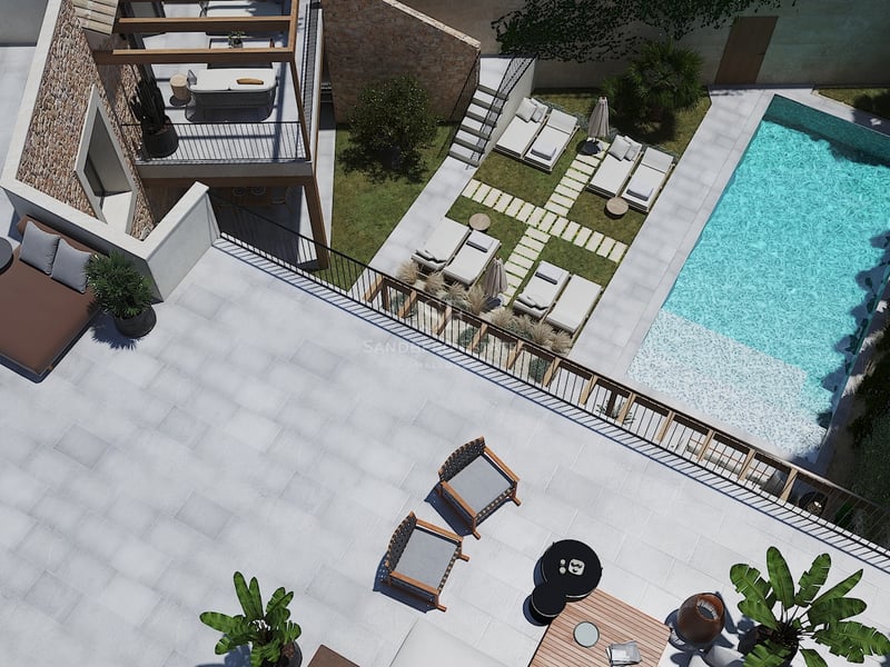 Vue aérienne d'une villa moderne avec piscine turquoise, murs en pierre et grands espaces de détente extérieurs.