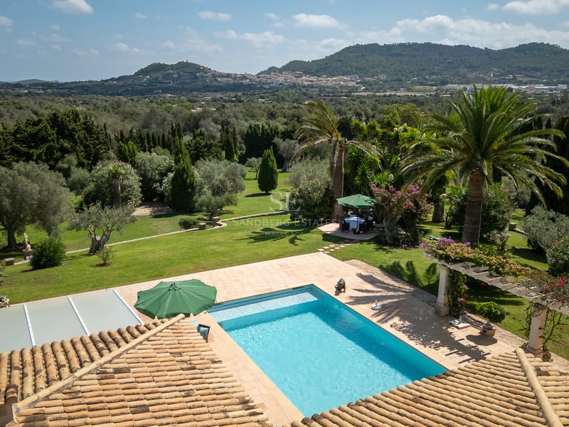 Vue surélevée d'une piscine rectangulaire entourée de terrasses en terre cuite et de jardins méditerranéens.