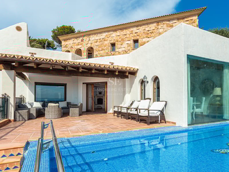 Vaste terrasse avec piscine à débordement et vue panoramique. Design moderne, mobilier d'extérieur élégant et végétation luxuriante.