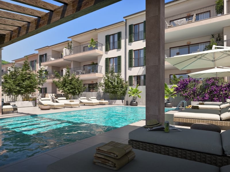 Turquoise pool with designer loungers, bougainvillea, and modern Mediterranean building under a blue sky.