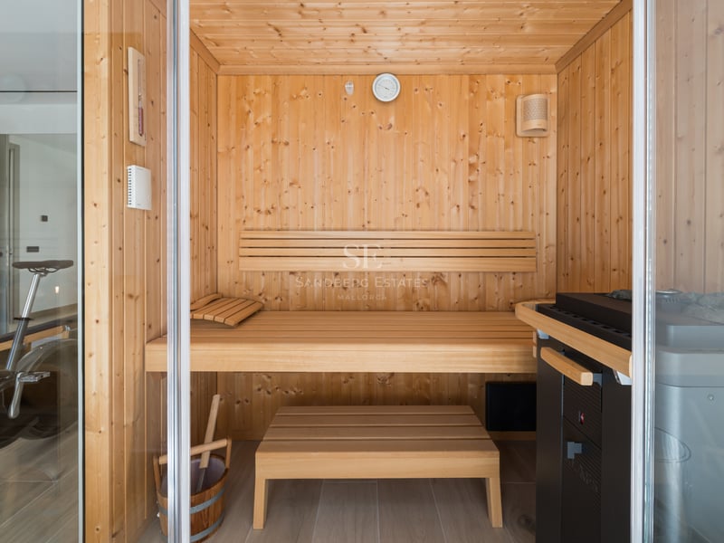 Grand balcon avec vue sur la mer. Design moderne, balustrade en verre, sol carrelé clair. Espace lumineux et élégant.