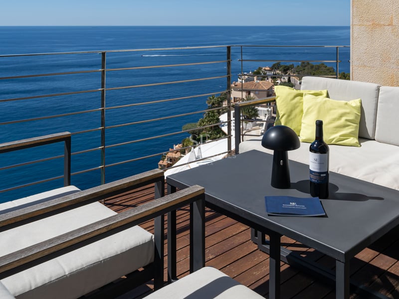 Modern terrace with lounge furniture and wooden decking overlooking the Mediterranean Sea.