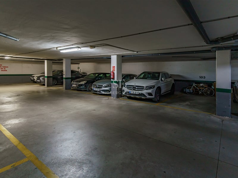 Rent underjordiskt garage med lyxbilar parkerade i numrerade rutor och gula markeringar.