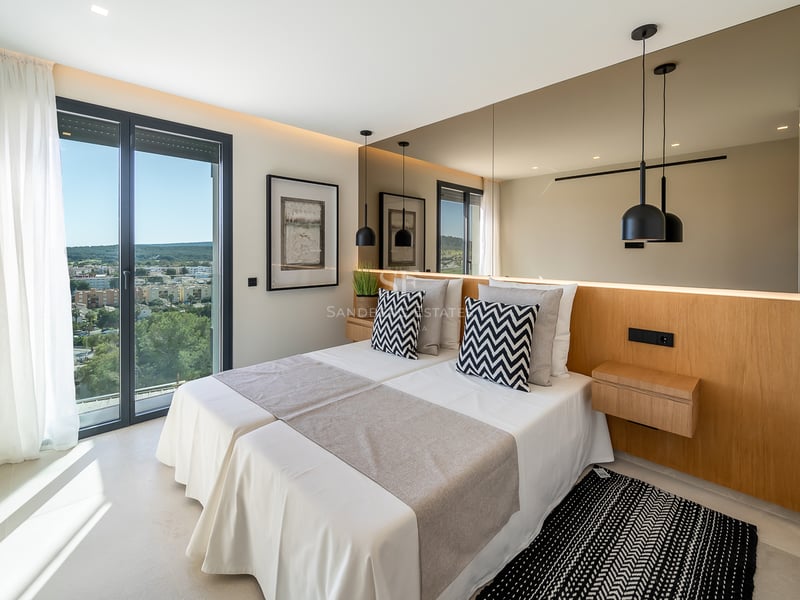 Chambre contemporaine avec lits jumeaux, tête de lit en chêne avec miroir intégré et porte-fenêtre sur terrasse.