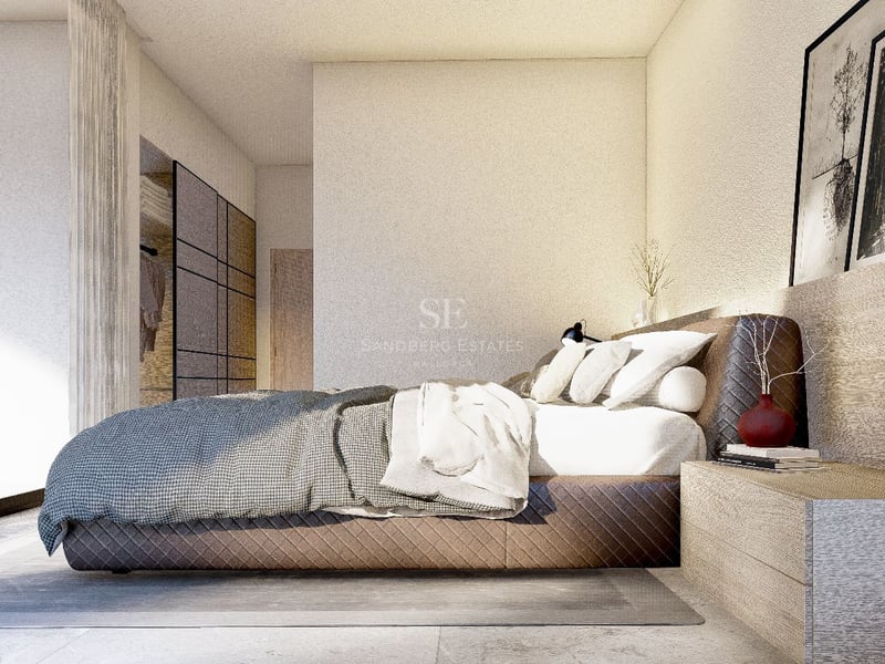 Chambre principale moderne avec lit matelassé, table de chevet en bois intégrée et grandes baies vitrées.