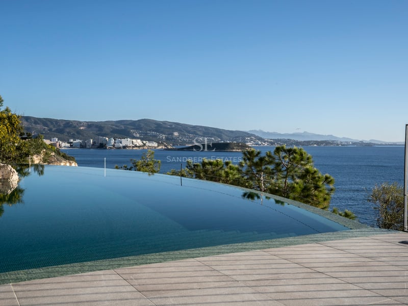 Infinity-Pool mit klarem blauen Wasser und Blick auf das Mittelmeer und die bergige Küste bei Tageslicht.