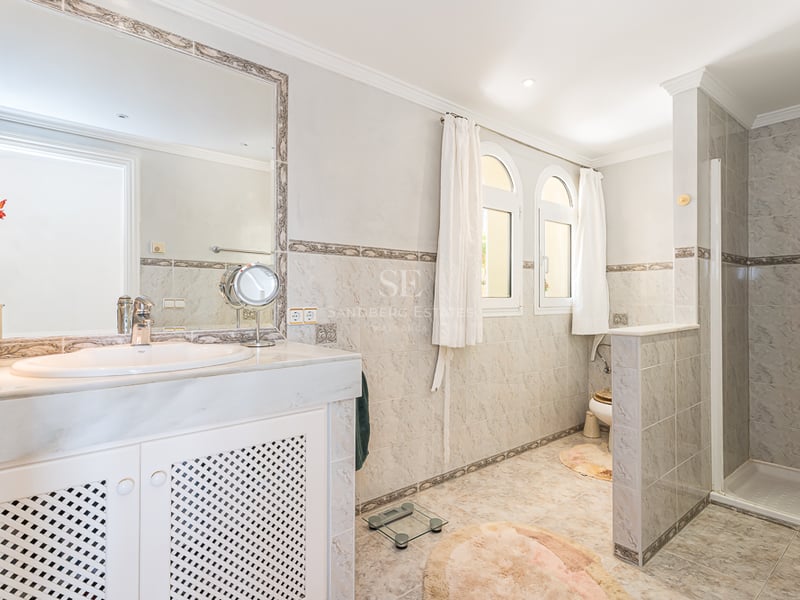 Exterior view of a luxurious modern house with pool, garden, and large windows. Minimalist architecture, high-quality finishes.