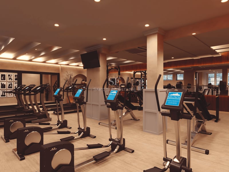 Intérieur d'une salle de fitness moderne avec vélos elliptiques, tapis de course et poids dans un cadre élégant.