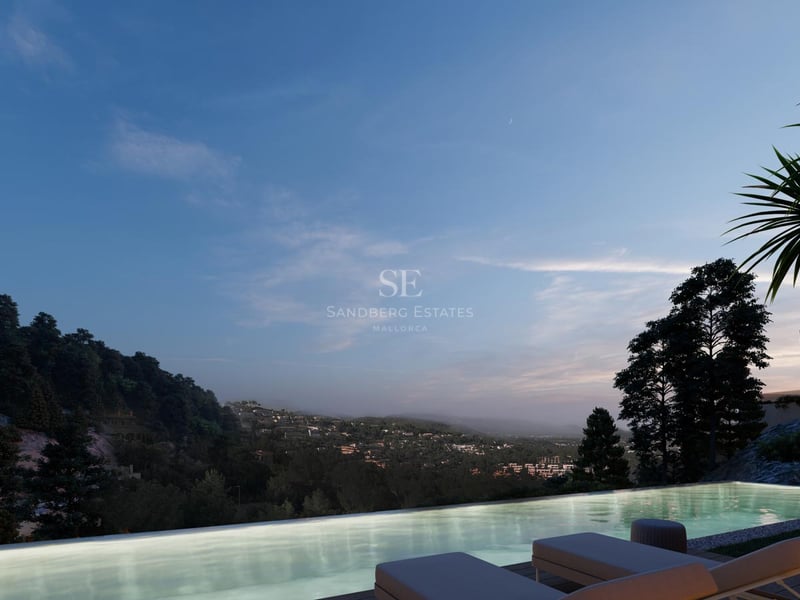 An illuminated infinity pool overlooking a forested valley and distant hills during twilight with sun loungers.