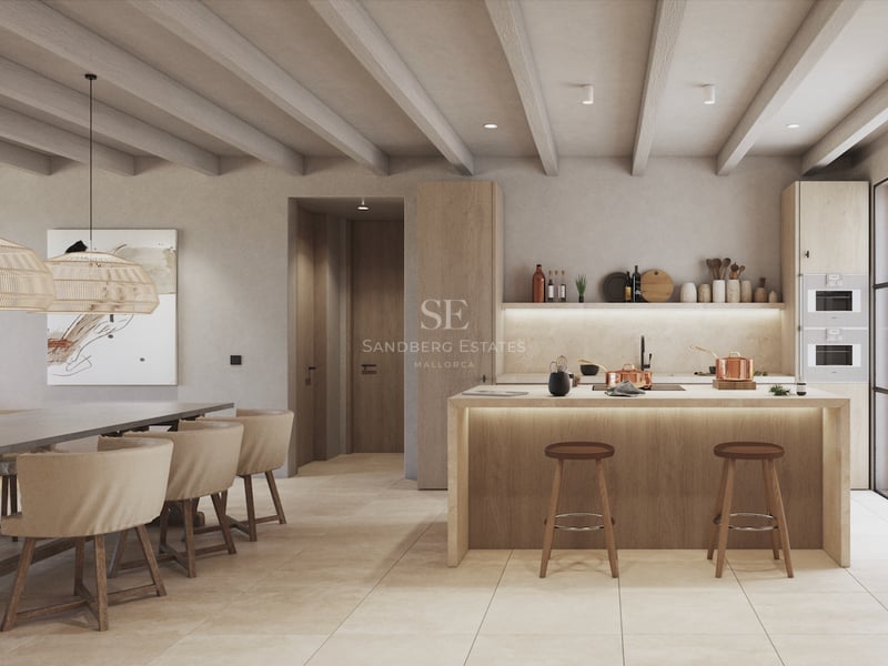 Cuisine moderne avec îlot en bois clair, poutres apparentes et électroménagers intégrés près de la salle à manger.