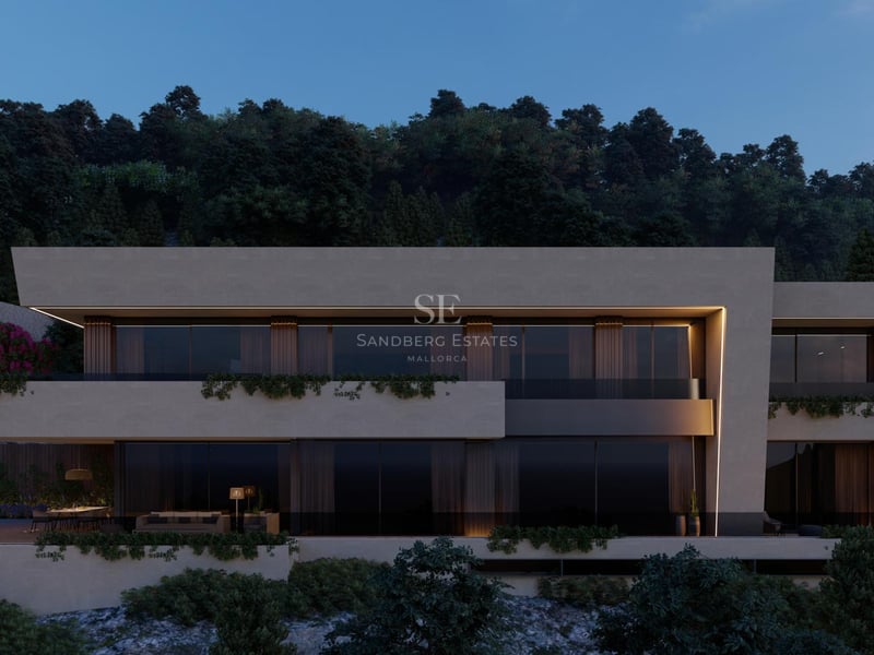 Vue nocturne d'une villa contemporaine à plusieurs niveaux avec baies vitrées et terrasses nichées dans la colline.