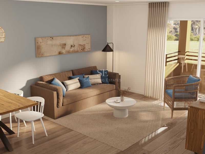 Salon avec canapé marron, fauteuil en osier, tapis en jute et porte vitrée ouvrant sur un balcon ensoleillé.