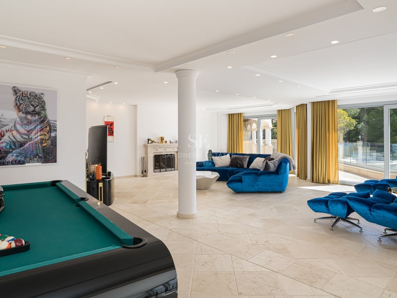 Großer moderner Spielraum mit blauem Sofa, Billardtisch, Steinboden und klassischem Kamin.