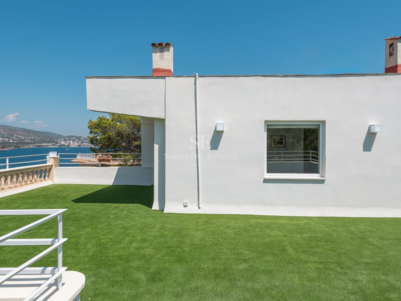 Grande terrasse blanche sur le toit avec gazon synthétique offrant une vue sur la mer Méditerranée.