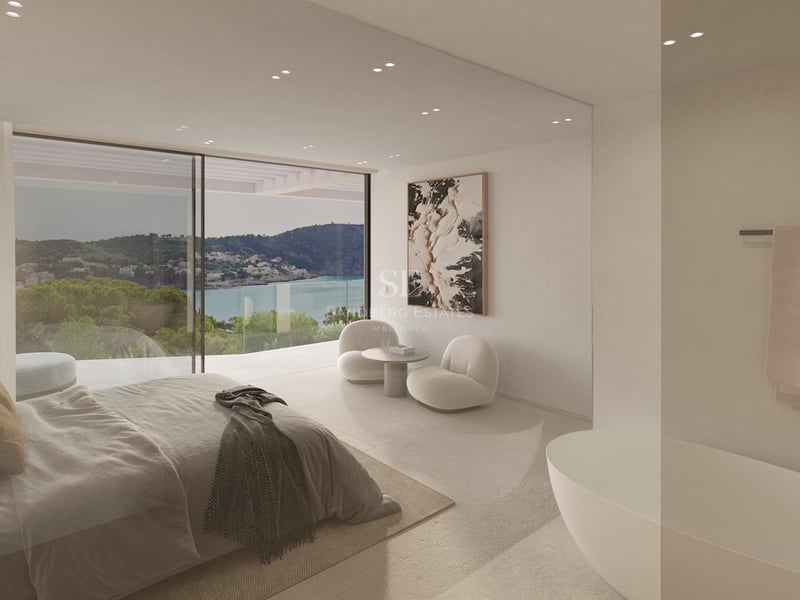 Modernes Schlafzimmer mit raumhohen Fenstern, Meerblick, integrierter Badewanne und Designermöbeln in Naturtönen.