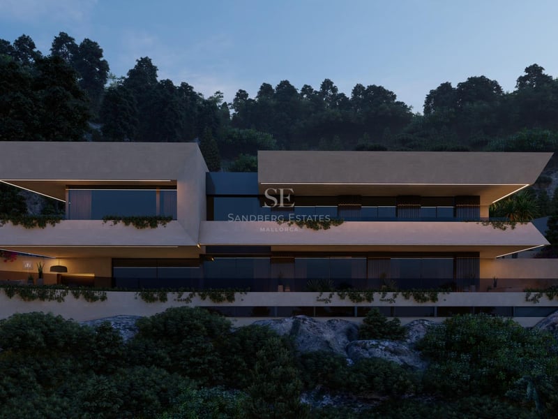 Dusk view of a contemporary multi-level villa with cantilevered balconies and integrated greenery on a rocky hillside.