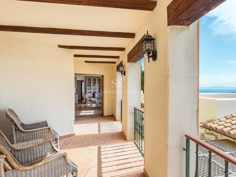 Vue extérieure d'une luxueuse maison avec piscine à débordement, entourée de verdure et présentant une architecture moderne et minimaliste.