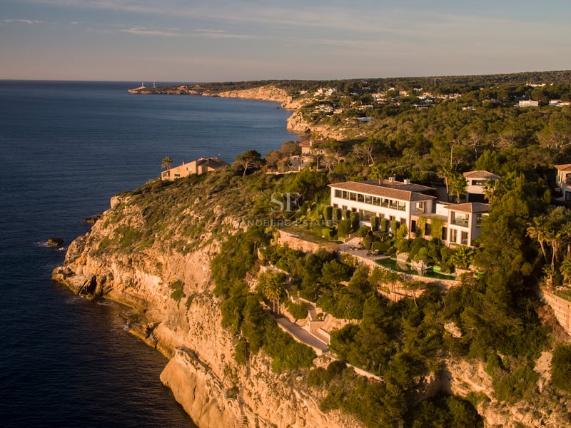 Luftaufnahme einer luxuriösen weißen Villa auf einer Klippe über dem Mittelmeer zur goldenen Stunde.