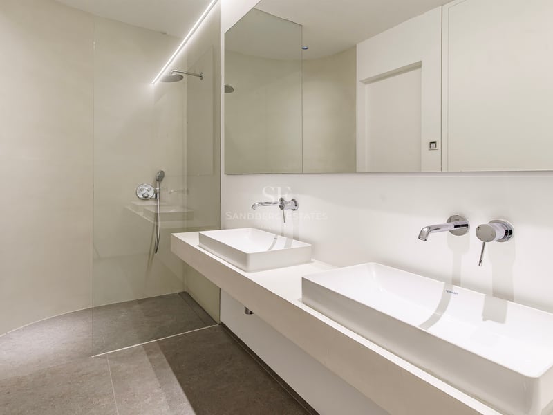 Salle de bain moderne avec deux vasques à poser, robinetterie chromée et douche à l'italienne vitrée.