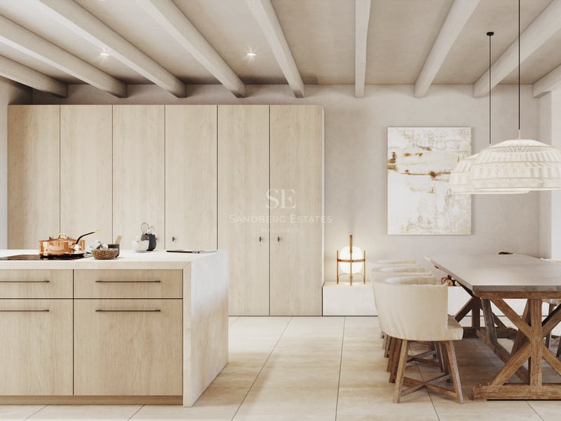 Cuisine moderne avec menuiserie en bois clair, îlot central et table à manger rustique sous des poutres apparentes.