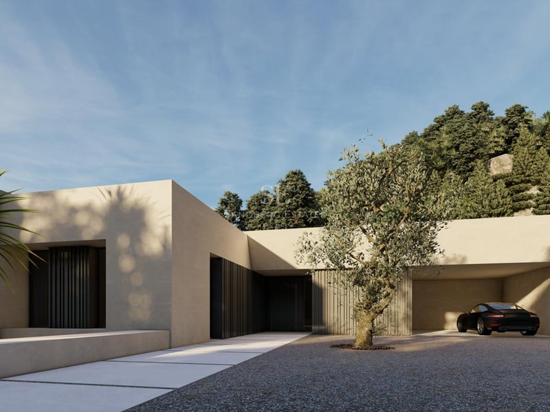 Modern sand-colored villa entrance featuring a gravel driveway, olive tree, and a black sports car in a carport.