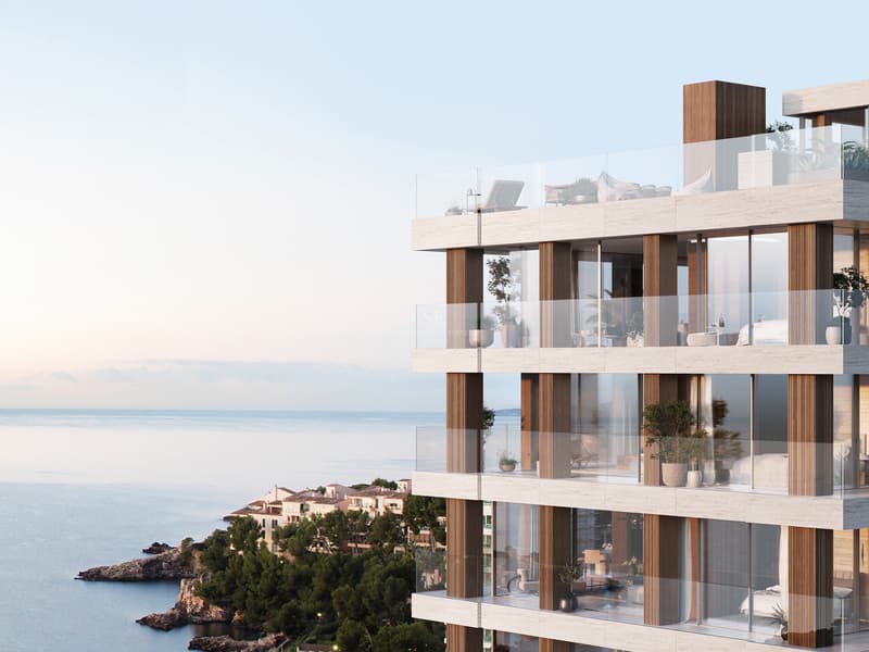 Façade d'un bâtiment moderne avec de grandes terrasses en verre et des accents de bois surplombant la Méditerranée.