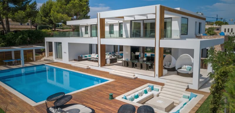 Villa contemporaine blanche avec grande piscine, terrasse en bois et salon extérieur encastré.