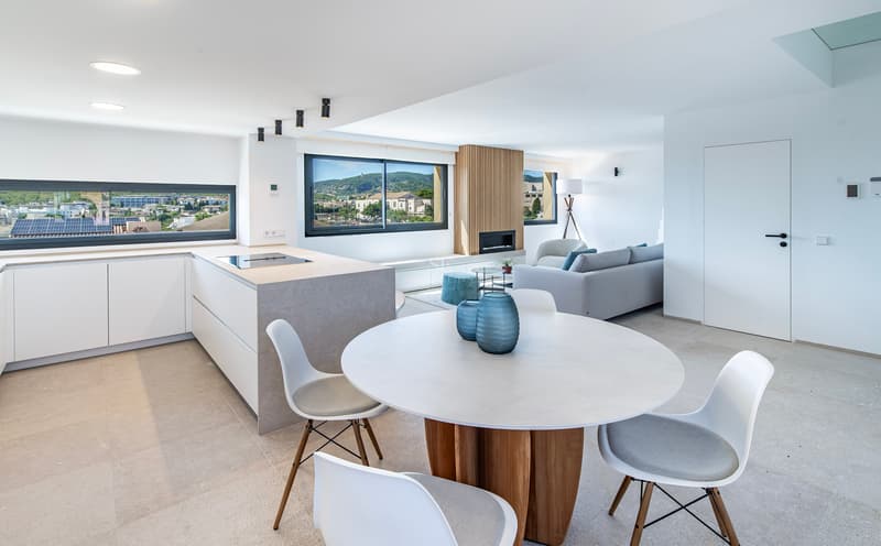 Espace lumineux ouvert comprenant une salle à manger, un îlot de cuisine moderne et un salon avec vue sur la ville.