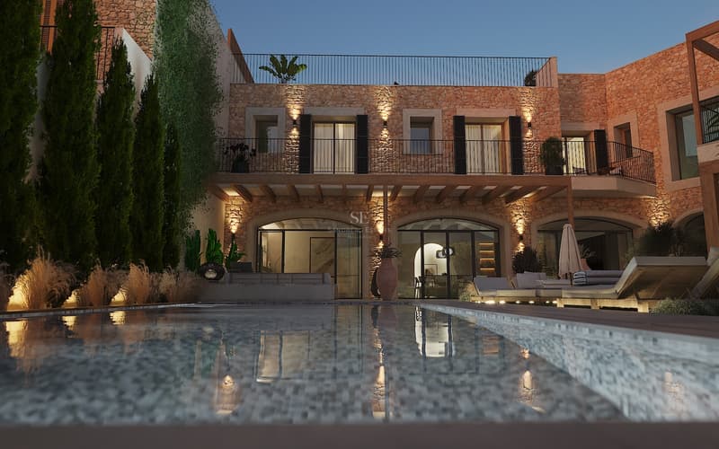 Vue nocturne d'une villa de luxe en pierre se reflétant dans une piscine calme sous un ciel de fin de journée.