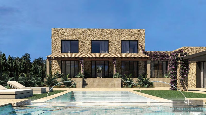 Villa moderna de piedra con piscina de diseño, chorros de agua, tumbonas y jardín mediterráneo.